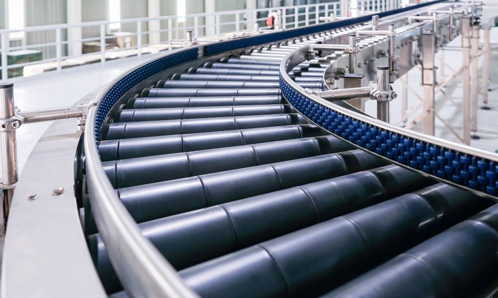 A roller conveyor system in a production line, showcasing multiple conveyor roller segments transporting various objects.